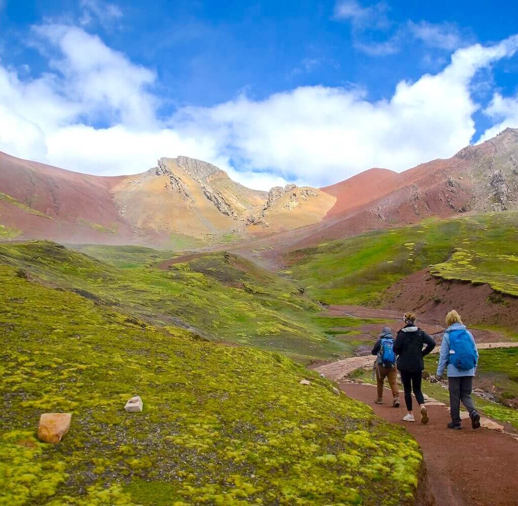 Hikers walking on trail to Palccoyo Rainbow Mountain in Cusco Peru Andes landscape