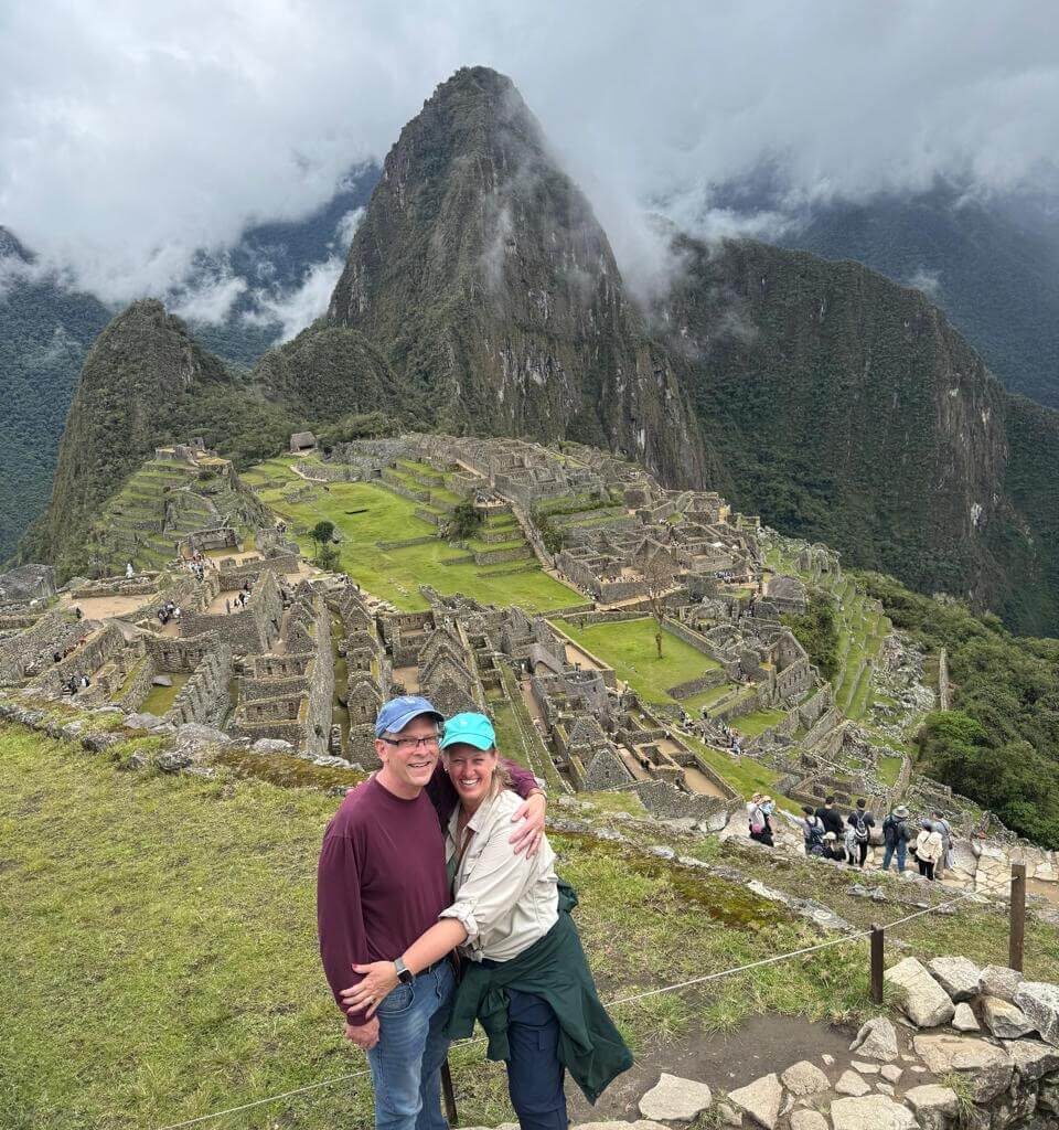Couple posing in front of Machu Picchu citadel and Huayna Picchu mountain in October.
